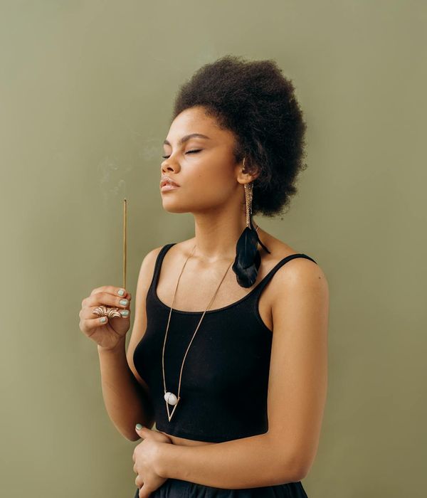 Woman in a calm yoga pose, embodying peace and balance in a minimalist setting.